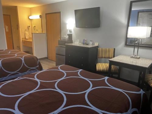 a hotel room with a bed and a television at Super 8 by Wyndham Cleveland TX in Cleveland
