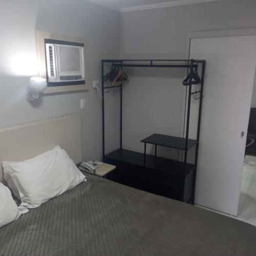 a bedroom with a bed and a microwave on the wall at Paulista Flat in São Paulo