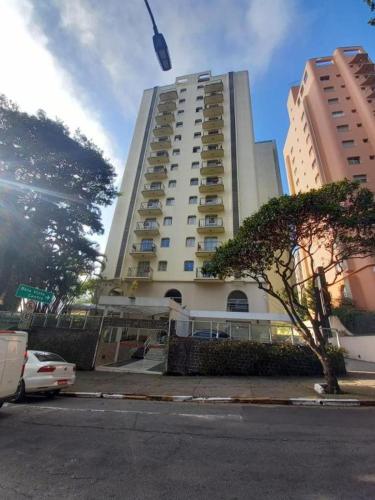 un grand bâtiment blanc avec un arbre devant lui dans l'établissement Paulista Flat 73, à São Paulo