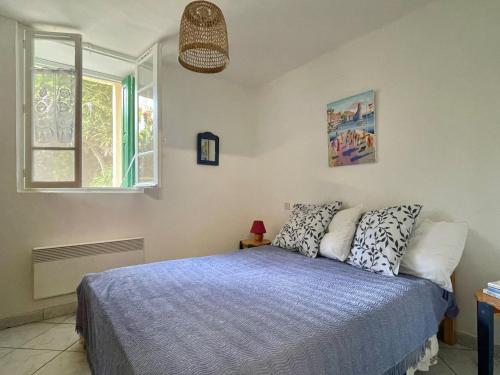 a bedroom with a bed and a window at Maison charmante à Collioure, à 200m de la plage, avec jardin et proche des commerces! - FR-1-309-368 in Collioure