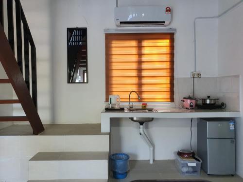 eine Küche mit einem Waschbecken und einem Fenster in der Unterkunft TIGA PENARIK 500m away to Penarik Jetty to Pulau Redang in Kampong Ru Sepuloh