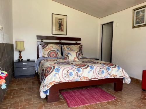 a bedroom with a large bed with a wooden headboard at Cabaña Campestre Miraluna in Choachí