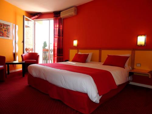 a hotel room with a large bed with red walls at Hotel Tennis International in Cap d'Agde