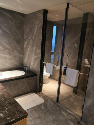 a bathroom with a shower and a sink and a toilet at Courtyard by Marriott Shanghai Hongqiao in Qingpu