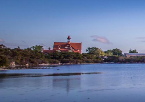 a large building sitting on the side of a river at Sudima Hotel Lake Rotorua in Rotorua