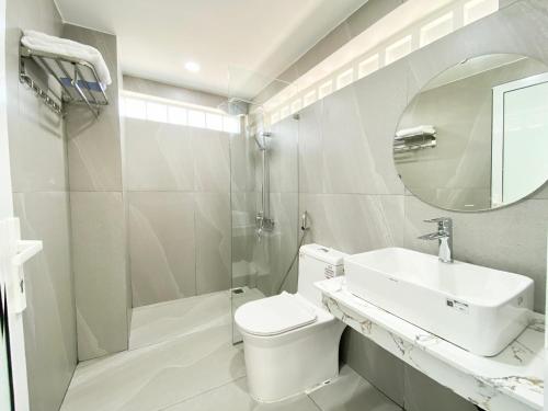 uma casa de banho com um lavatório, um WC e um espelho. em Moc Son Apartment - Attractive price for week and month stay em Da Nang