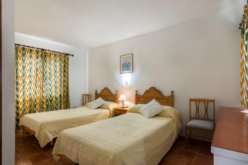 a hotel room with two beds and a window at Villa Bonaire in Alcudia