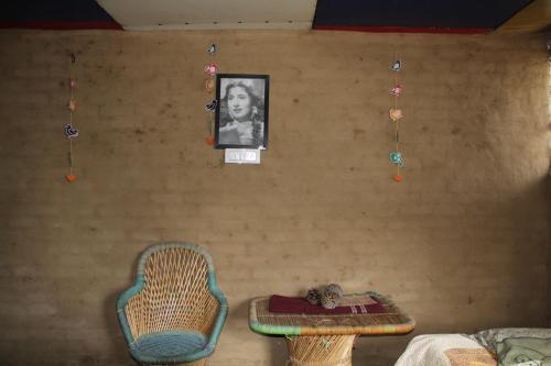 a room with a table and chairs and a picture on the wall at 11 Gaon Mudhouse Homestay in Lansdowne
