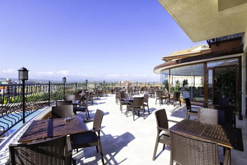 a patio with tables and chairs on a balcony at Adalya Art Side - Ultra All Inclusive in Side