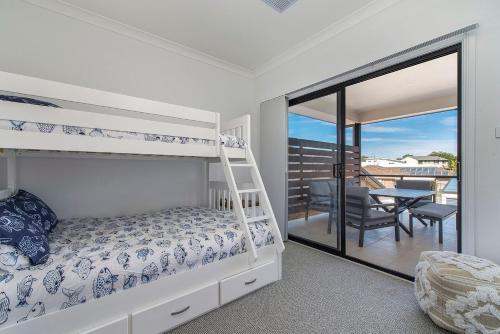 Un dormitorio con una litera y un balcón. en Pacific Sounds, en Dunbogan