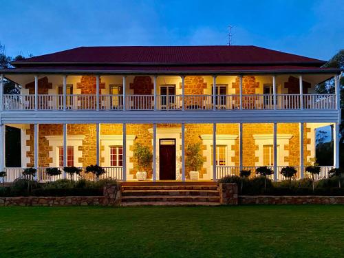 a large white house with a large porch at Glamping at Buckland Estate in Irishtown