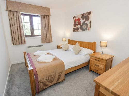 a bedroom with a bed and a desk and a window at Brunston Castle Lodge in Girvan