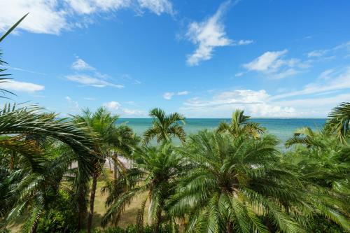 a group of palm trees on the beach at GRANDVRIORESORT ISHIGAKIJIMA Ocean's Wing & Villa Garden in Ishigaki Island