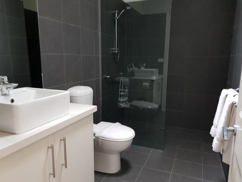 uma casa de banho com um WC, um lavatório e um chuveiro em Ozone Tower em Queenscliff