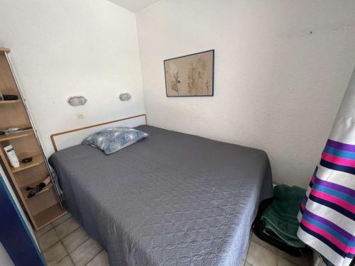 Dormitorio pequeño con cama con almohada en Appartement Le Barcarès, 2 pièces, 5 personnes - FR-1-431-206, en Le Barcarès