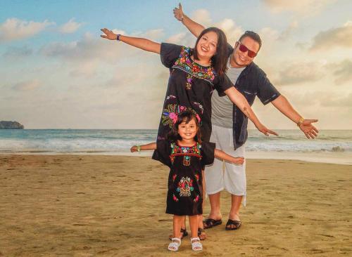 Casa ALOA Ixtapa في اكستابا: رجل وامرأة وطفل على الشاطئ