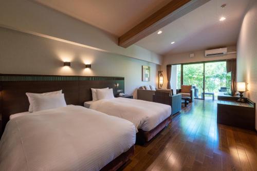 a hotel room with two beds and a large window at GRANDVRIORESORT ISHIGAKIJIMA Ocean's Wing & Villa Garden in Ishigaki Island