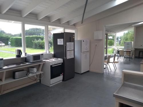uma cozinha com um fogão, um frigorífico e uma mesa em South Brighton Holiday Park em Christchurch