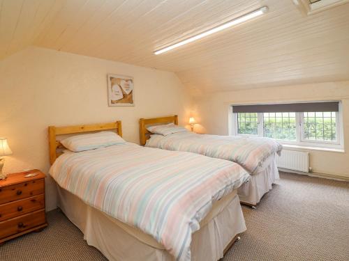 a bedroom with two beds and a window at Lena Cottage in Great Driffield