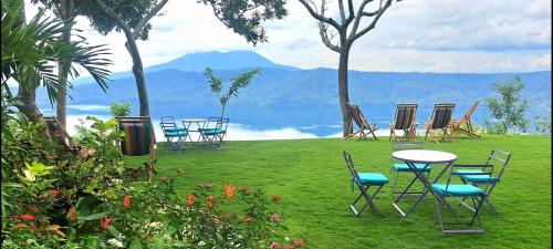 a group of chairs and tables on a lawn near the water at El Guayacán in Valle la Laguna