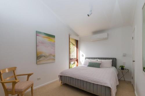 a bedroom with a bed and a chair at Nixon House in Benalla