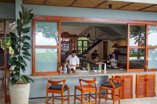 a restaurant with a bar with orange chairs at El Guayacán in Valle la Laguna