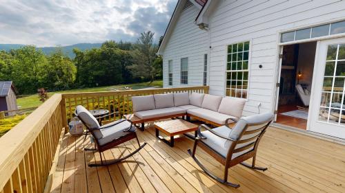 a patio with a couch and chairs on a deck at Wine Country Modern Farmhouse on 10 Acres and Pool in Afton