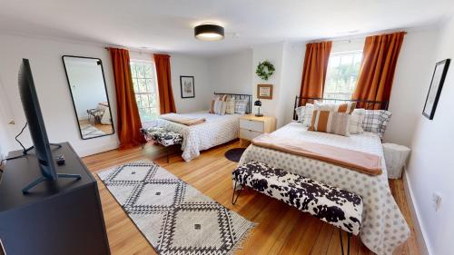 a living room with two beds and a flat screen tv at Wine Country Modern Farmhouse on 10 Acres and Pool in Afton