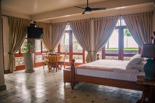 1 dormitorio con 1 cama, mesa y sillas en El Guayacan Retreat, en El Edén