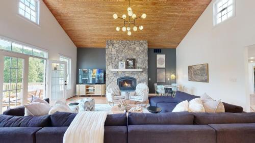 a living room with a couch and a fireplace at Wine Country Modern Farmhouse on 10 Acres and Pool in Afton