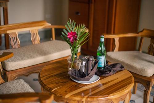 a table with a bottle of beer and a vase of flowers at El Guayacán in Valle la Laguna