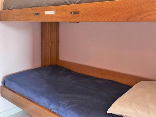 une couchette inférieure d'un lit superposé avec un matelas bleu dans l'établissement Studio avec terrasse, parking privé proche mer - FR-1-251-506, à Bormes-les-Mimosas