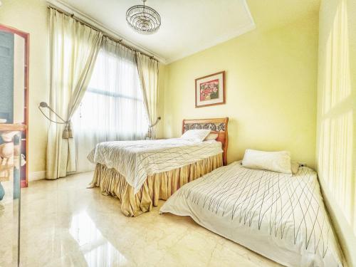 a bedroom with two beds and a window at Batavia Apartment ST in Jakarta