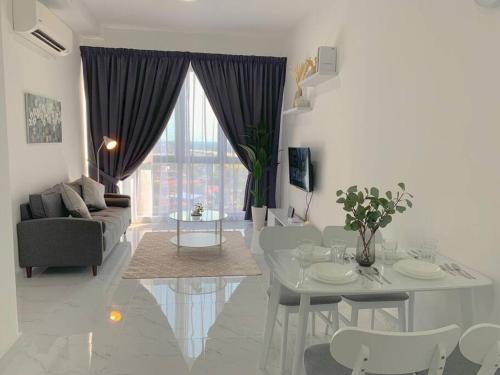 een witte woonkamer met een tafel en een bank bij #Netflix #Cuckoo Troika Kota Bharu Homestay 01812 in Kota Bharu