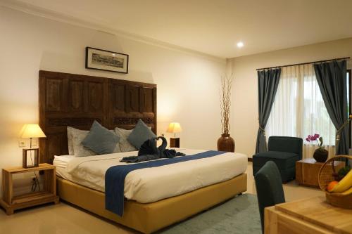 a bedroom with a large bed and a room with a chair at SARE HOTEL MALIOBORO in Jetis