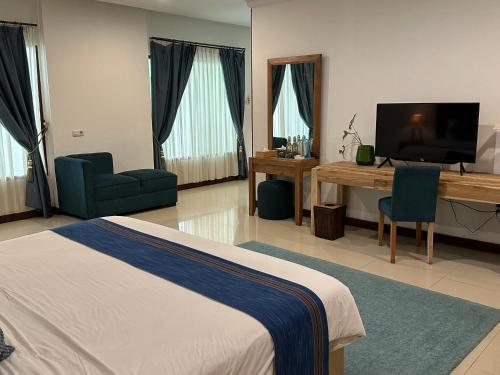 a bedroom with a bed and a desk and a television at SARE HOTEL MALIOBORO in Jetis