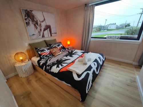 a bedroom with a bed and a large window at Vitamin Sea Beach House in Riverton