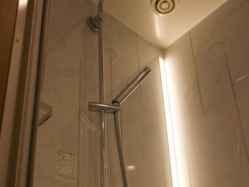 een douche in een badkamer met een glazen deur bij SUN HOUSE in Makkari