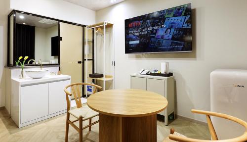 a kitchen with a table and a sink and a television at Hotel Intro Chuncheon in Chuncheon