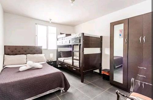 1 dormitorio con 1 cama, 1 litera y espejo en Alojamiento "Cómo en CASA" cerca al Aeropuerto!!, en Bogotá