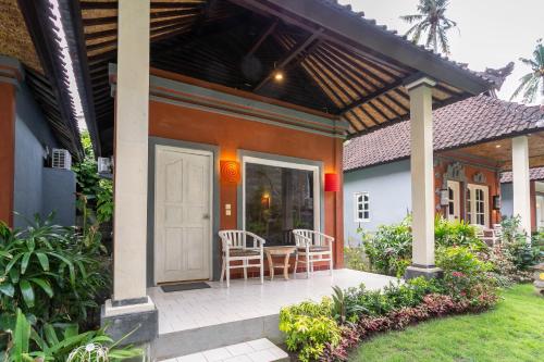 a house with two chairs and a table on a porch at Utama Villas Beach Front Candidasa in Candidasa