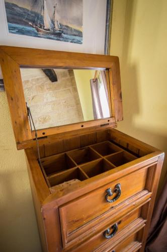 a wooden drawer with a mirror inside of it at The Burrow Guest House in Tarxien