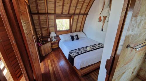 een kleine slaapkamer met een bed en een raam bij Gili T Sugar Shack in Gili Trawangan