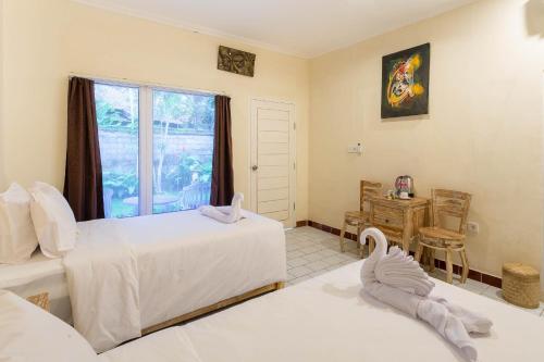 a bedroom with two beds and a window at Utama Villas Beach Front Candidasa in Candidasa