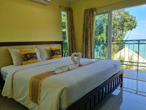 a bedroom with a large bed with a large window at Chom By The Sea in Ao Nam Mao