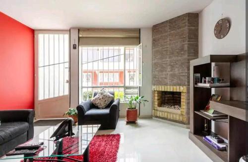 a living room with a couch and a fireplace at Alojamiento "Cómo en CASA" cerca al Aeropuerto!! in Bogotá