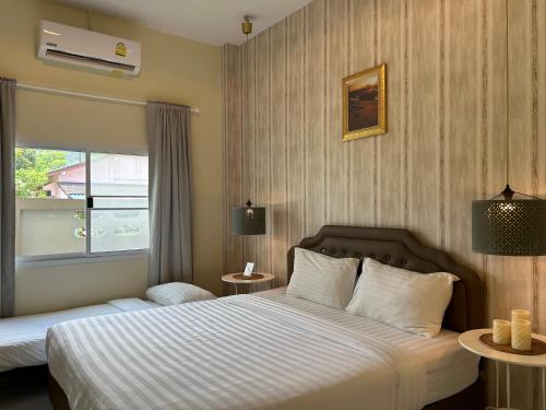 a hotel room with two beds and a window at W House Ranong 1Bedroom villa in Ranong