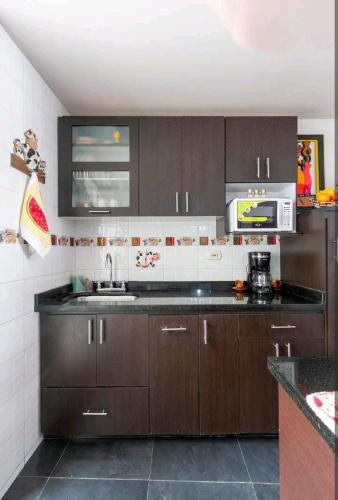 a kitchen with a sink and a microwave at Alojamiento "Cómo en CASA" cerca al Aeropuerto!! in Bogotá