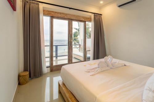 a bedroom with a bed with a view of the ocean at Utama Villas Beach Front Candidasa in Candidasa