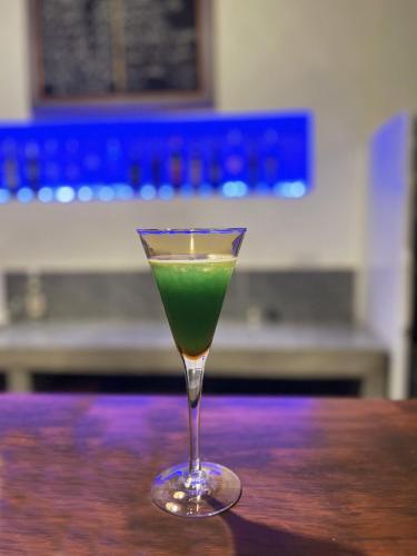 a green drink in a glass sitting on a table at Naga Lodge in Luang Prabang